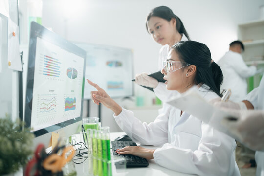 Scientists analyzing data results on laboratory computer monitors, focusing on research, innovation, experiment, teamwork, and biotechnology in modern lab environments for scientific development - Powered by Adobe