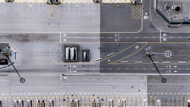 Detailed aerial photo capturing structured road markings, intersections, port lanes, and shadowed light poles in the Long Beach port district.