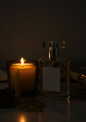 Candle and perfume bottle at night