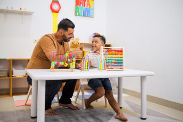 Happy Father And Preschool Son Playing With Abacus In Living Room