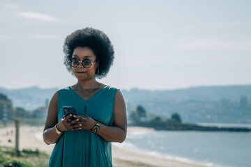young woman using mobile phone on beach promenade