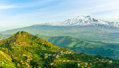 Fototapeta premium panoramic view of a national park with green mountains with palace and great white snowy top of a mountain on a blue cloudy sky background. Travel beautiful landscape of green hills. 