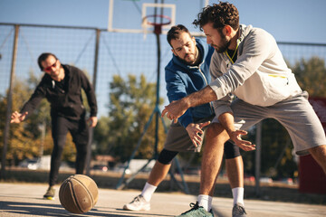 Group of friends playing basketball outdoors.