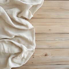 A light fabric is softly draped on a natural wooden surface, creating a calm and minimalist scene.