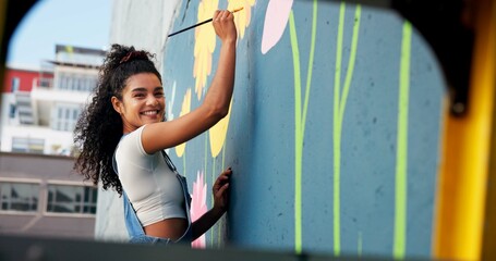 Painting, portrait and woman with wall mural for art design, creative project and community service. Artist, happy and person with paintbrush for flower decor, inspiration and DIY hobby in city © CineLens25/peopleimages.com