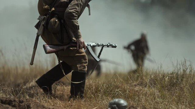 Soviet stormtrooper with PPSh-41 submachine gun runs across battlefield. Historical reconstruction simulating Great Patriotic War battle. Red Army infantry attack, World War 2 combat on Eastern Front