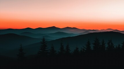 Obraz premium Majestic mountain range silhouetted under an orange and light sky
