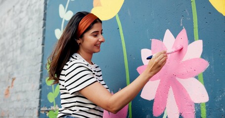 Painting, mural and woman in city with flowers for art design, creative project and community service. Artist, happy and person with paintbrush outdoor for wall decor, inspiration and DIY hobby © CineLens25/peopleimages.com