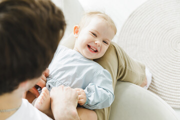 Best dad ever. A man tickles his daughter who is lying on his lap on the couch. father and child