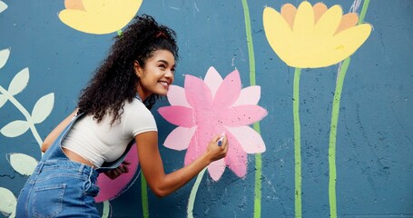 Woman, excited or artist painting on wall for mural, drawing flowers or community service at building. Smile, outdoor or happy girl with color for floral decoration, renovation or project for design