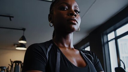 Strong and Serious Female Athlete Standing Proudly in Gym - Powered by Adobe