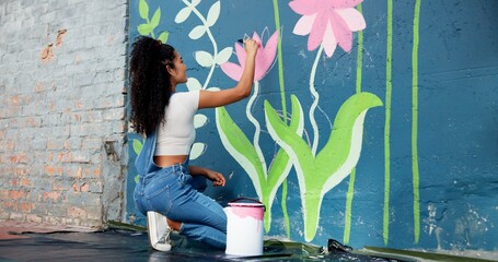 Woman, back or artist painting on wall for mural, drawing flowers or community service at building. Creative person, outdoor or girl with color for floral decoration, renovation or project for design © CineLens25/peopleimages.com