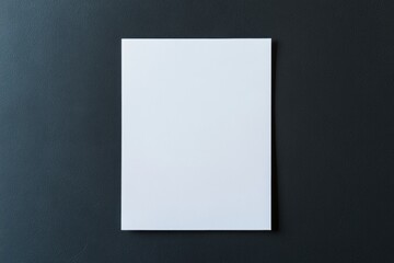 Blank white sheet of paper placed on a dark textured background. Minimalist composition for mockup design, branding, corporate identity, or stationery presentation with clean space for text or logo.