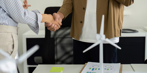Sustainability teamwork: Professionals shaking hands on eco-friendly goals