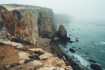 Coastal cliffs meet foggy ocean.  Rocky shoreline