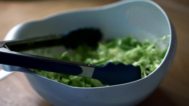 Lettuce leaves in a plate.
Green salad for weight loss.
Deep dish with chopped cabbage.
Fresh vegetable salad in summer.
Preparation of green salad with cabbage and cucumbers.
Vegan, veganfood, salad,