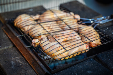 Chicken being grilled in a grid close-up