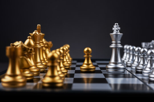 King silver chess standing confront of the golden chess team. - Powered by Adobe
