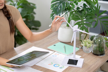 ESG sustainability evaluation with tablet and wind turbine in focus