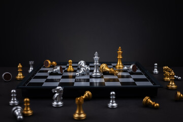 Golden and silver chess include king queen horse ship and pawn on dark background