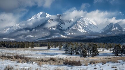 First storm of winter begins to coat a mountain range in snow with the leading edge of clouds visibly advancing across the peaks