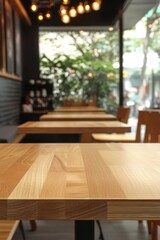 Wooden table focus in a light airy modern cafe with a soft and relaxing ambience light and warm background with a window view