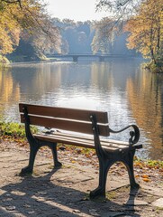 Obraz premium Tranquil autumn scene bench overlooking a serene lake with reflections and golden foliage in peaceful park