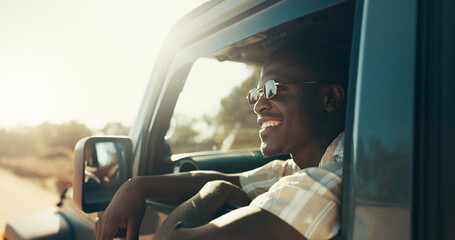 Black man, road trip and smile with sunglasses by window with driving, journey and excited for safari in summer. African person, happy and face in vehicle, transport and travel at sunset in Kenya © KayContri01/peopleimages.com