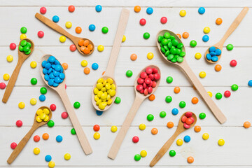 delicious colorful sweet candies on spoon on colored background . Confectionery decor top view with copy space