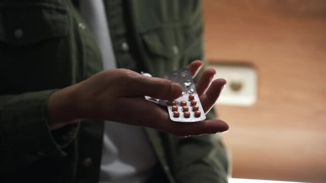 antidepressant and pills for the virus in a person's hands.
Treatment of colds.
Disease prevention.
A sick man with a sore throat takes pills.
Pills and vitamins for pain.
Sore throat.
Pills close-up