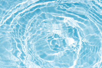 Blue water with ripples on the surface. Defocus blurred transparent blue colored clear calm water surface texture with splashes and bubbles. Water waves with shining pattern texture background.