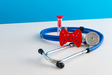Anatomical model human thyroid gland closeup with hourglass and stethoscope