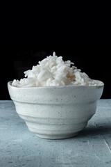 White rice, cooked. A bowl of boiled long grain rice, a simple side dish, side view with copy space