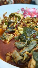Spicy Dish with Green Leaves and Red Sauce