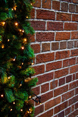 Side view on christmas garland with lanterns on brick wall, vertical shot