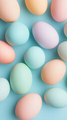 Colorful pastel eggs arranged on a vibrant light blue background in a flat lay composition