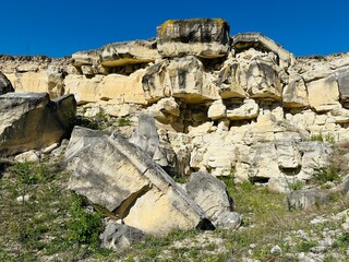 sandy-gypsum cut of the earth in a quarry for the extraction of gypsum. Mountain textures of different soil layers with deposits of sand, clay, gypsum, quartz and gypsum ore, after erosion.