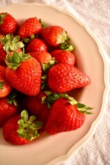 Bowl with organic strawberries – fresh seasonal fruit full of vitamins and natural flavor.