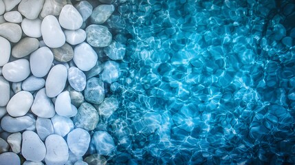 Natural Contrast Between Smooth White Stones and Clear Blue Water Surface in Bright Setting
