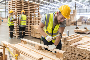 Male workers carpenter wearing safety uniform and yellow hard hat working using hammer nail to on...
