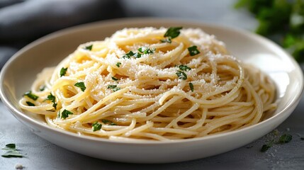 Delicious freshly prepared spaghetti pasta dish topped with grated cheese and chopped herbs served in a white bowl for a homemade Italian meal experience