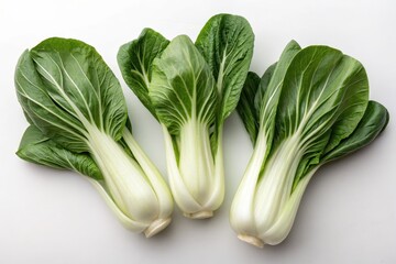 Fresh bok choy with vibrant green leaves on a white background.