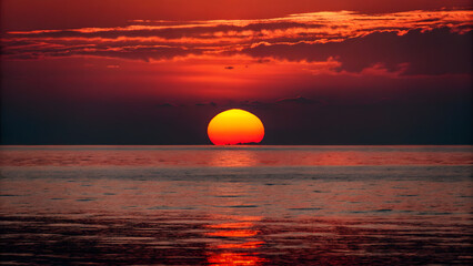 Obraz premium The setting sun the sea surface reflects orang