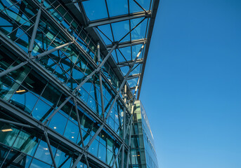 Modern Architectural Glass Building Exterior Design Against Blue Sky. Steel Framework, Contemporary Structure, Office, Urban Cityscape.