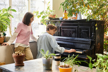 People engaged in creative activities in a vibrant art studio filled with plants and inspiration