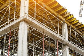 Extensive scaffolding providing platforms for work in progress on a new apartment block,Tall building under construction with scaffolds,Construction Site of New Building © bukhta79