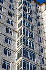 Extensive scaffolding providing platforms for work in progress on a new apartment block,Tall building under construction with scaffolds,Construction Site of New Building