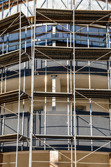Extensive scaffolding providing platforms for work in progress on a new apartment block,Tall building under construction with scaffolds,Construction Site of New Building