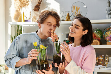 Creative couple exploring floral art in a vibrant studio filled with decorations and plants