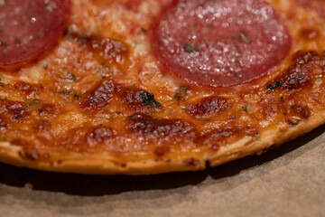 a salami pizza on baking paper